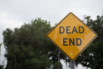 DEAD END diamond yellow and black old rustic sign, close up with copy space on right