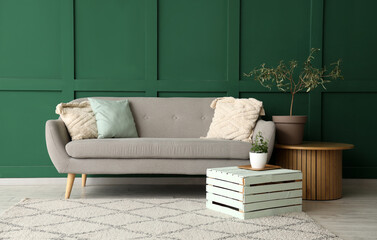 Interior of minimalistic living room with grey sofa, houseplant and coffee table