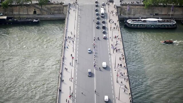 Many pedestrians and cars seen from above on Iena bridge over the river Seine in Paris, France.