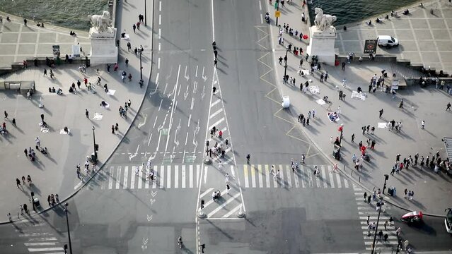 Many pedestrians and cars seen from above on Iena bridge over the river Seine in Paris, France.