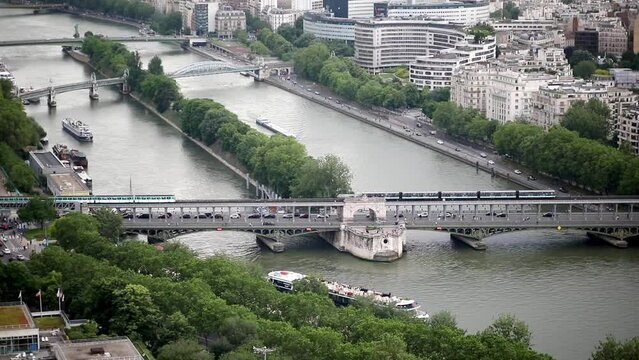 Aerial scenic view of the river Seine with Bir-Hakeim bridge with subway trains on it and touristic boats in Paris, France.