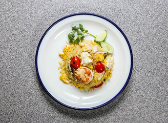 thai fried rice withh seafood with, shrimp, prawn, squid, cherry tomato, cucumber and coriander served in plate isolated on grey background top view of hong kong fastfood