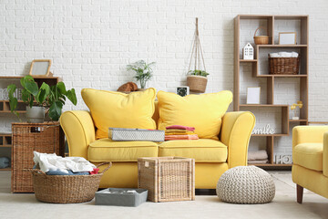 Stylish interior of light living room with clean clothes