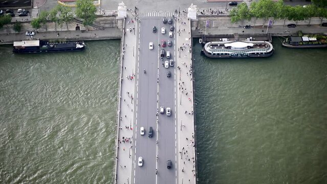 Many pedestrians and cars seen from above on Iena bridge over the river Seine in Paris, France.