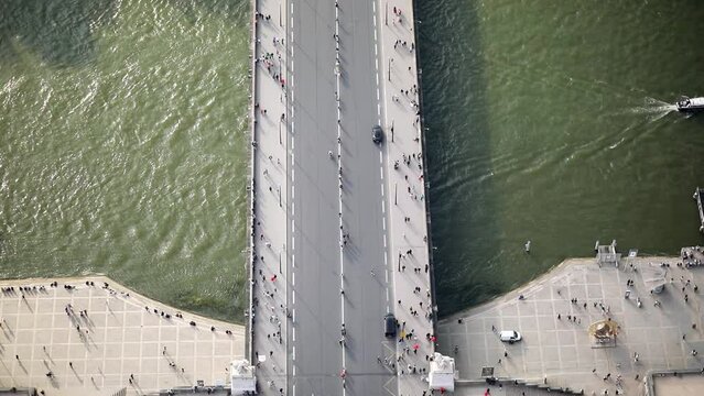 Many pedestrians and cars seen from above on Iena bridge over the river Seine in Paris, France.