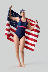 Female swimmer with USA flag on light background