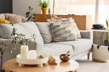 Tibetan bowl with wooden balls and candles on table in living room, closeup
