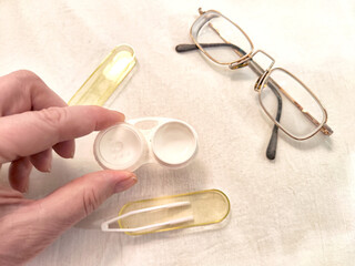 A set for contact lenses with a container, forceps, glasses. The concept of correcting myopia....