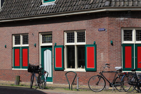 Kerkstraat Street House Facade with Red and Green Shutters in Monnickendam, Netherlands - Powered by Adobe
