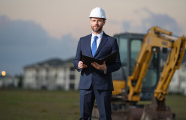 Construction business owner. Man in suit and hardhat halmet at building construction site. Civil...