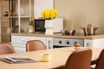 Vase with beautiful daffodil flowers on kitchen counter
