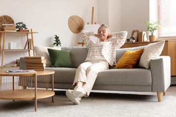 Young woman resting on sofa in stylish living room