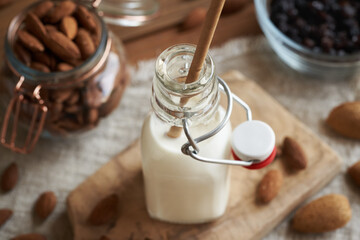A bottle of vegan almond milk on a table with ecological paper straw. Zero waste.
