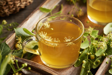 A cup of herbal tea with fresh linden or Tilia cordata flowers harvested in spring