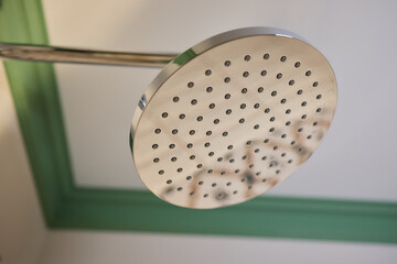 Contemporary stainless steel showerhead in a bathroom, featuring modern design and function