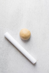 Overhead view of egg noodles dough a marble countertop, homemade egg noodles and egg pasta dough balls, process of making fresh egg noodles