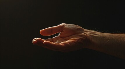 Hand holding object in darkness