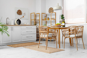 Interior of kitchen with dining table, chairs, shelving unit and lamp
