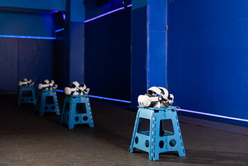 VR headsets and controllers arranged on stools in gaming room with modern, minimalist design and...