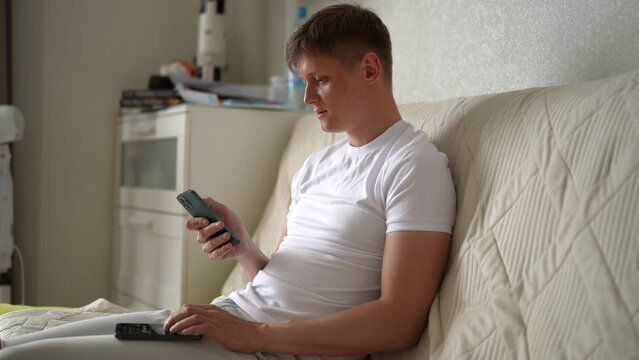 Motivated young man clicking with fingers on two smartphones screen to farming new popular Hamster Kombat cryptocurrency coin in online application. Crypto trader male extract crypto coins on phone.