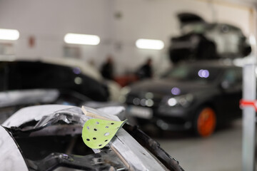 Various parts of car on stands for painting. Garage painting car service. Repairing car body work...