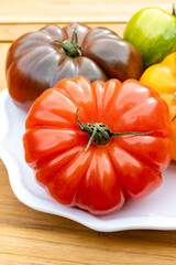 Variety of colorful tasty ripe french tomatoes from farmers market in Brittany on plate, close-up