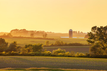 Farm and fields and trees at sunset in northeastern Iowa during the late spring