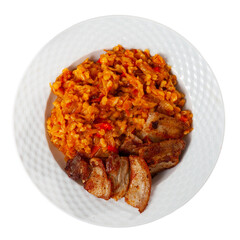 Traditional Spanish dish is roasted brisket pork. Grilled pork topped with pearl barley and vegetable carrot. Hearty homemade dish. Isolated over white background