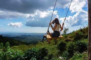 A girl on a swing overlooking the mountains