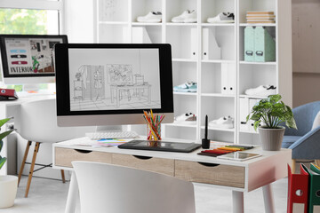 Graphic designer's workplace with computer and fabric samples in office