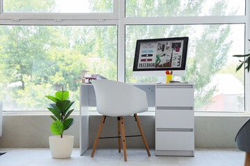 Graphic designer's workplace with computer near window in office