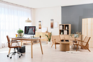 Interior of graphic designer's office with workplace and armchairs
