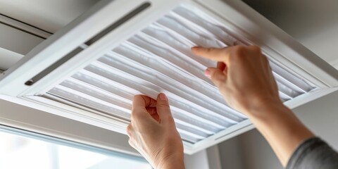 A close-up of a person using a DIY air filter made from affordable materials to improve indoor air quality