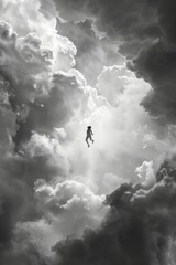 Silhouette of a man fluctuating in the clouds. Black and white photo.