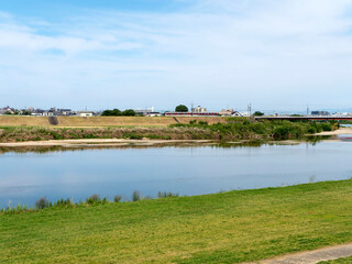 大和川を渡る近鉄道明寺線の電車と河川敷の公園