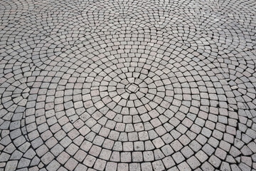 Stone road texture. Stone walk background. Granite cobblestoned pavement background. Rough brick road. Side walk. Stone cladding pavement.