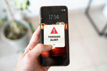 New tornado alert notification on the smart phone. Bad weather and strong wind concept.