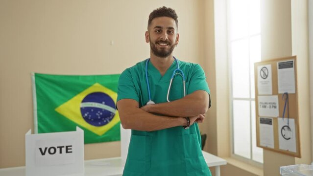 A young hispanic man in green scrubs with a stethoscope stands confidently in an indoor electoral college room in brazil, with a brazilian flag and a voting sign visible in the background.