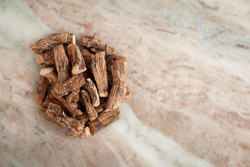 A pile of Dry Organic Sweet flag or Vach (Acorus calamus) roots, on a marble background. Top view