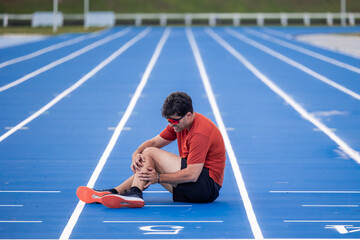 Injured Runner Clutches Leg in Pain on Athletic Track After Muscle Injury