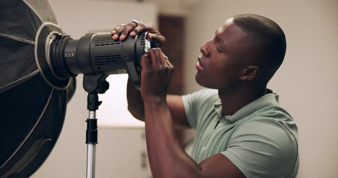 Photography, man and lighting setup in studio for production, preparation and equipment for photoshoot. Photographer, black person and setting camera for flashlight, spotlight and behind the scenes