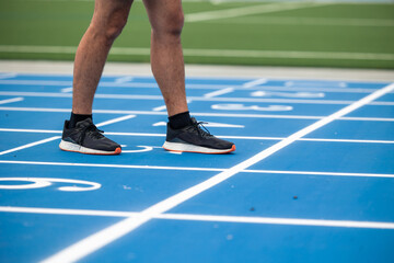 closeup of Runner's Feet on Starting Line of Blue Running Track