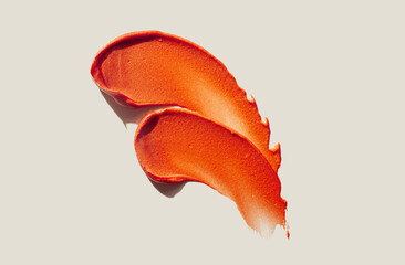 Orange red lipstick swatch isolated on gray beige