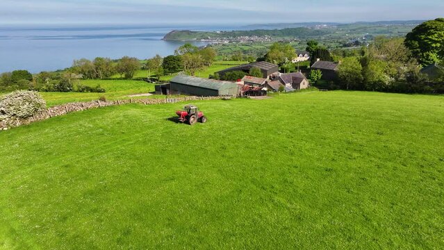 Aerial view of Massey Ferguson 390T Tractor sowing artificial manure spreading in a field at Ballygawn Farm Co Antrim Northern Ireland 06-06-2024