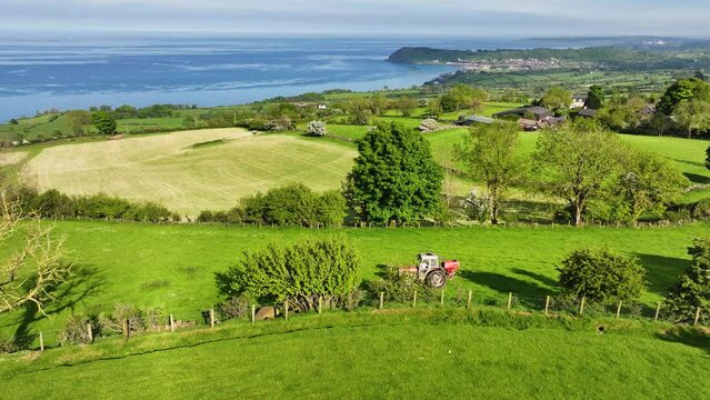 Aerial view of Massey Ferguson 390T Tractor sowing artificial manure spreading in a field at Ballygawn Farm Co Antrim Northern Ireland 06-06-2024