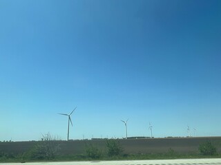 Panoramic view of wind farm or wind park, with high wind turbines for generation electricity with copy space. Green energy concept.
