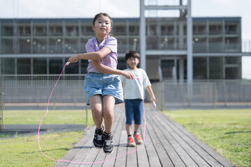 Multiple elementary school children, girls and boys, jumping rope in school yards, etc.