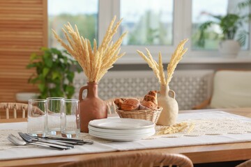 Clean dishes, dry spikes and fresh pastries on table in stylish dining room