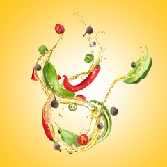 Cooking oil splash with chili peppers, basil and allspice in air on golden background