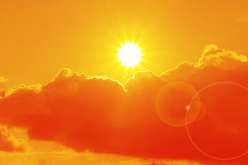 Orange sky with sun and clouds during hot summer weather